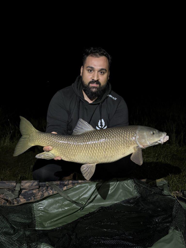 Pescador con barbo capturado en sesión de pesca con material especializado